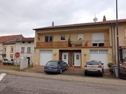 dwa samochody zaparkowane przed domem w obiekcie Appartement Gauche avec balcon w mieście Hargarten-aux-Mines