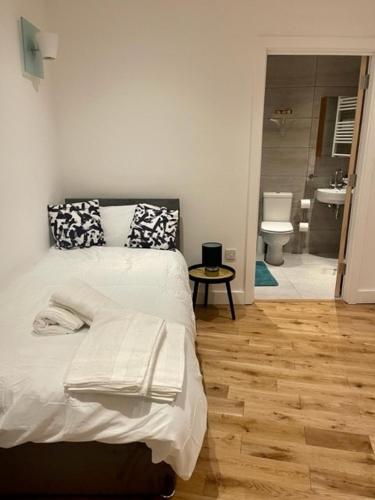 a bedroom with a bed and a bathroom with a toilet at Monument Prime Location in the City of London in London