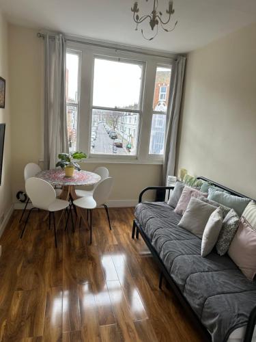ein Wohnzimmer mit einem Sofa und einem Tisch in der Unterkunft apartment Lavender Hill in London
