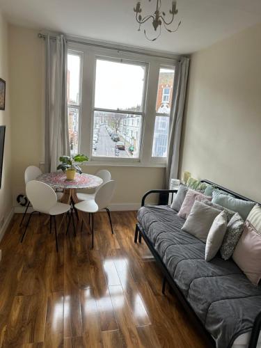 a living room with a couch and a table at apartment Lavender Hill in London