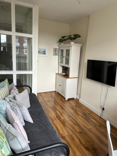 sala de estar con sofá y TV de pantalla plana en apartment Lavender Hill, en Londres