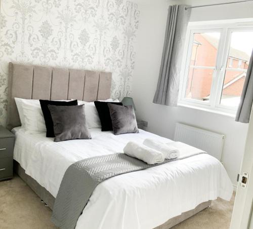 a bedroom with a large white bed with a window at Barley House in Andover