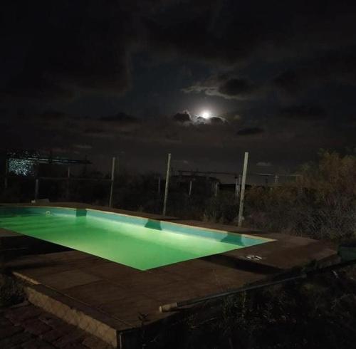 una piscina vacía por la noche con la luna en Aguara House, Pedemonte - Mendoza en Mendoza