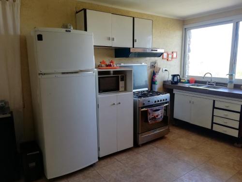 a kitchen with a white refrigerator and a stove at Aguara House Pedemonte Mendoza in Mendoza