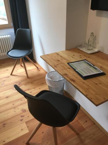 a desk with a black chair and a wooden table at Bed&Bike Tremola San Gottardo in Airolo