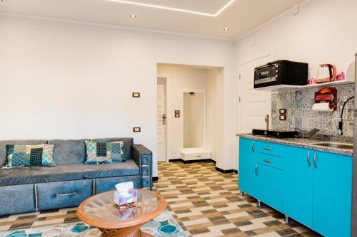 een woonkamer met een blauwe bank en een tafel bij Villa golden life apartments, new property with pool access in Luxor