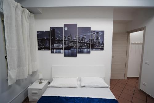 um quarto com uma cama com quatro pinturas na parede em AYN Apartment em Tiriolo