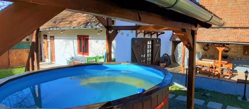 a large swimming pool in a house with a roof at Padláskincsek Vendégház in Nagybörzsöny