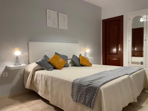 a bedroom with a large bed with yellow and blue pillows at Apartamento San Francisco in Lucena