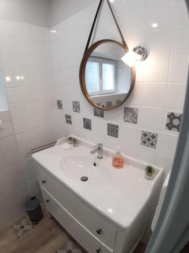 uma casa de banho branca com um lavatório e um espelho em Villa MAGDA à 30 mn mer pour vacances ou cure em Dax