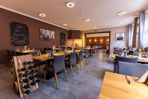 a restaurant with tables and chairs and a chalkboard on the wall at Hotel Fronhof Mettendorf in Mettendorf