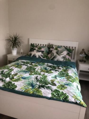 um quarto com uma cama com um edredão verde e branco em DOM NAD STAWEM em Kazimierz Dolny