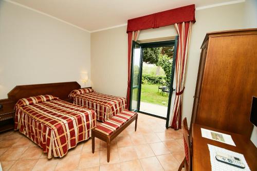 1 dormitorio con 2 camas y puerta corredera de cristal en HOTEL VULCI en Montalto di Castro