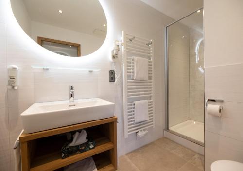 a white bathroom with a sink and a shower at ThälerHäusle in Furtwangen