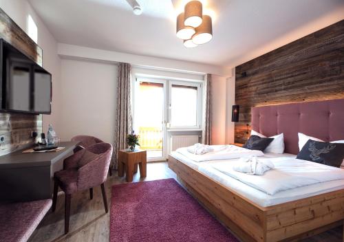 a bedroom with a bed and a desk and a window at ThälerHäusle in Furtwangen
