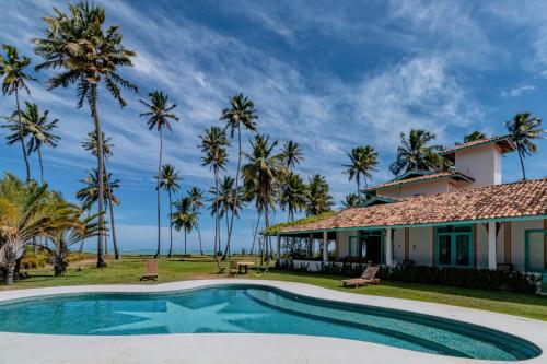 una casa con piscina y palmeras en Casa Brasileira - Hotel Galeria en Pôrto de Pedras
