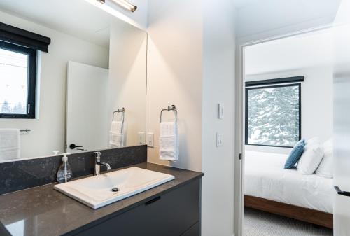 baño con lavabo y cama en Revel In The Stoke by Revelstoke Vacations en Revelstoke