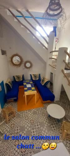 a living room with blue couches and a table at Dar jilali in Taghazout