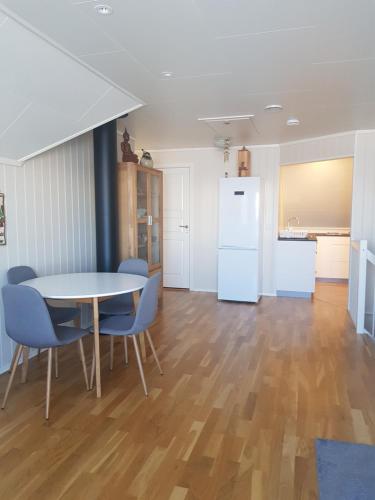 d'une salle à manger avec une table, des chaises et un réfrigérateur. dans l'établissement 2 Bedrooms Apartment in Sommarøy Island, à Tromsø