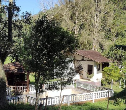 una casa blanca con una valla blanca en Casa de Campo no Parque Estadual da Serra do Mar en São Luiz do Paraitinga