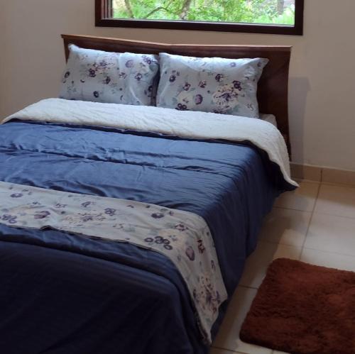 a bedroom with a bed with blue sheets and a window at Casa de Campo no Parque Estadual da Serra do Mar in São Luiz do Paraitinga