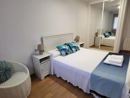 博伊羅的住宿－Playa Jardin Boiro，一间卧室配有一张带镜子和椅子的床