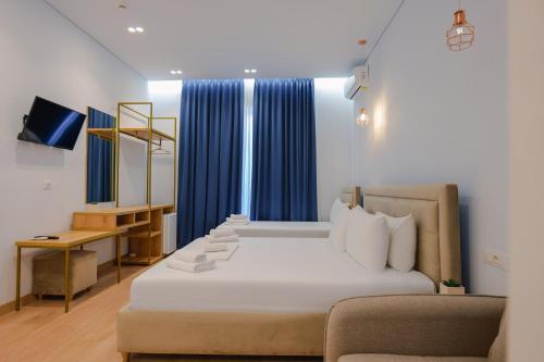 1 dormitorio con cama blanca y sofá en Otto Hotel, en Ksamil