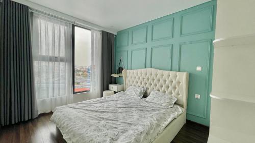 a bedroom with a white bed and a blue wall at LAD Apartment & Homestay Hải Phòng - Hoàng Huy Grand Tower in Hai Phong