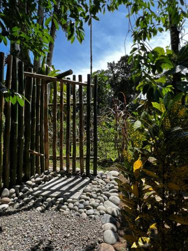 a fence on a path with rocks and trees at Whispering Wisdom in Cahuita