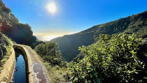 a view of a river from a hill with the sun in the sky at Holiday Apartment Sunset Ocean in Ribeira Brava