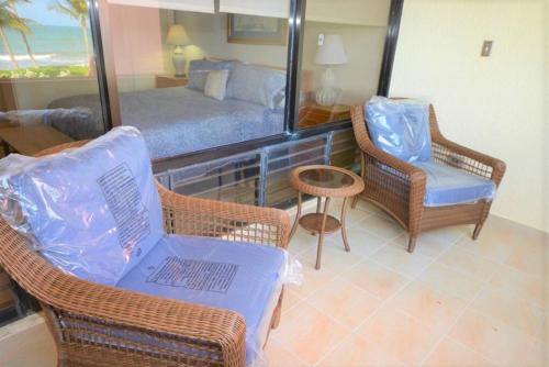 a living room with a bed and chairs and a mirror at Beachfront Getaway for two! in Humacao