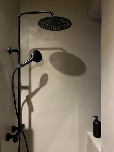 a black lamp with a shadow on a wall at Casa Caleido in Verona