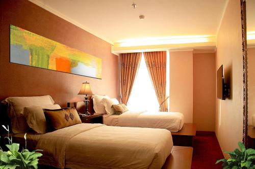 a hotel room with two beds and a window at Lion Hotel & Plaza Manado in Manado