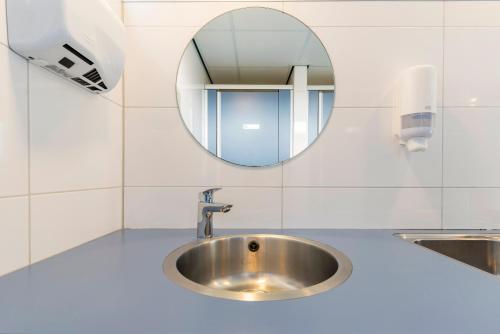 a bathroom with a sink and a mirror at Tiny Camping Pod in Warmond