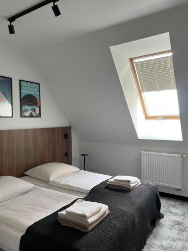 a bedroom with two beds with towels on them at Hotel ZAWRAT Ski Resort & Spa in Białka Tatrzanska