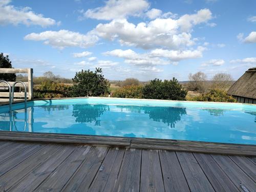 una gran piscina en una terraza de madera en La Maraiquaise en Marais-Vernier
