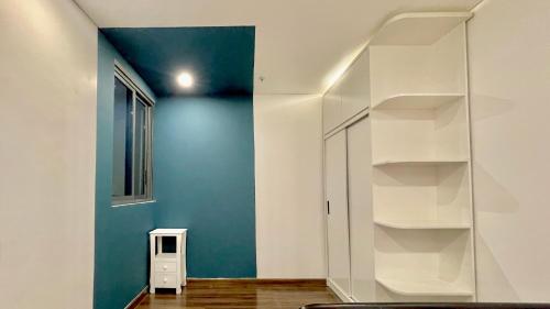 a room with a blue wall and white shelves at LAD Apartment & Homestay Hải Phòng - Hoàng Huy Grand Tower in Hai Phong