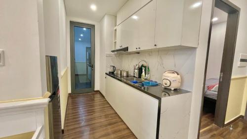 a kitchen with white cabinets and a counter top at LAD Apartment & Homestay Hải Phòng - Hoàng Huy Grand Tower in Hai Phong