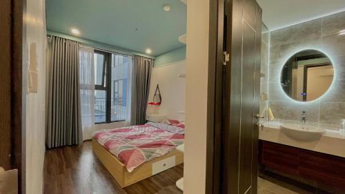 a bedroom with a bed and a sink and a mirror at LAD Apartment & Homestay Hải Phòng - Hoàng Huy Grand Tower in Hai Phong