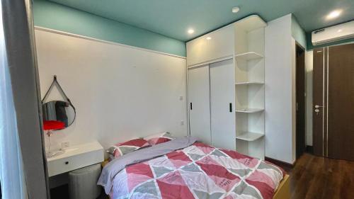 a bedroom with a bed and a desk and a mirror at LAD Apartment & Homestay Hải Phòng - Hoàng Huy Grand Tower in Hai Phong