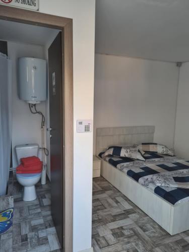 a bathroom with a bed and a toilet in a room at Holiday Village in Eforie Nord