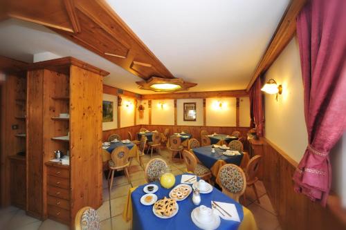 a dining room with blue tables and chairs at Agritur Ruatti in Rabbi
