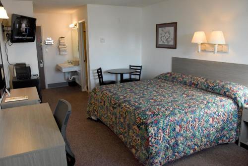 a hotel room with a bed and a table at Yellowstone River Inn in Glendive