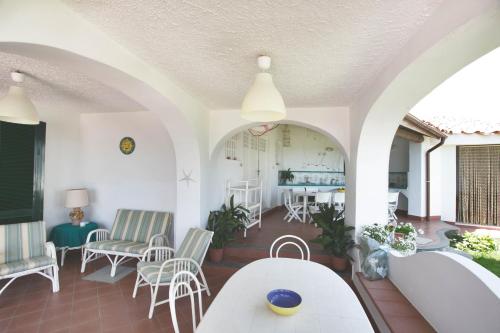 un salon avec des chaises blanches et une table dans l'établissement villa stella del mare, à Acireale