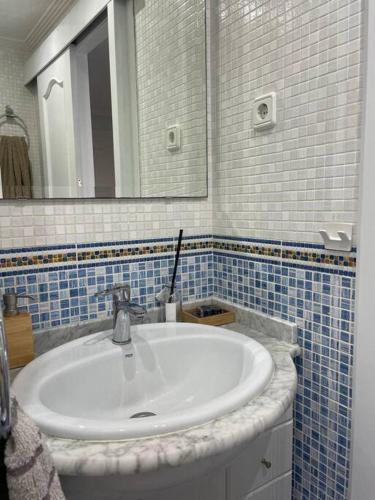 a bathroom with a white sink and a mirror at Cal SalMaré seafront apartment with rooftop terrace and pool in Calafell
