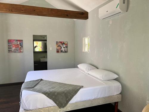a bed with white sheets and pillows in a room at Jamaica Colors Hotel and Eco-Retreat in Port Antonio
