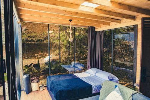 Habitación con cama en un porche cubierto en Giüg Refugio en Medellín