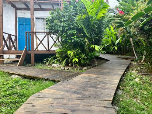 a wooden path leading to a house with a blue door at Jamaica Colors Hotel and Eco-Retreat in Port Antonio