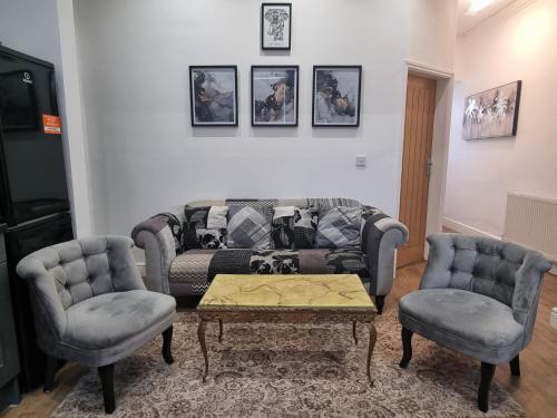 a living room with a couch and two chairs at Cheerful 4 bedroom close to Uclan, Preston City Center in Preston