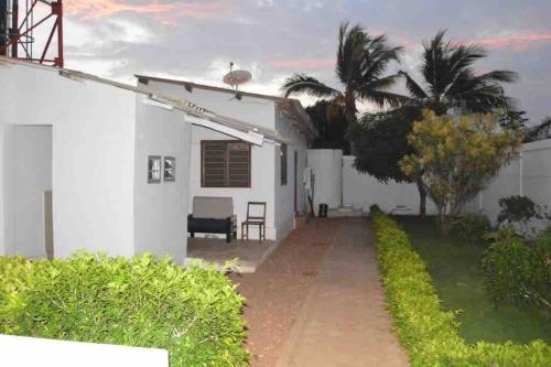 a white house with a palm tree in front of it at Gloryphil House in Lomé